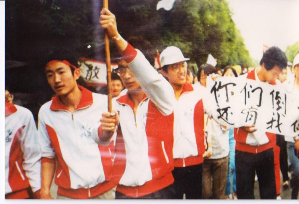 On May 17, 1989, over 1,000 students from the High School Affiliated to Renmin University marched in support of the university students on hunger strike. The banner says: “When you fall, you still have us!” Jiang Jielian, on left, is one of the march’s organizers